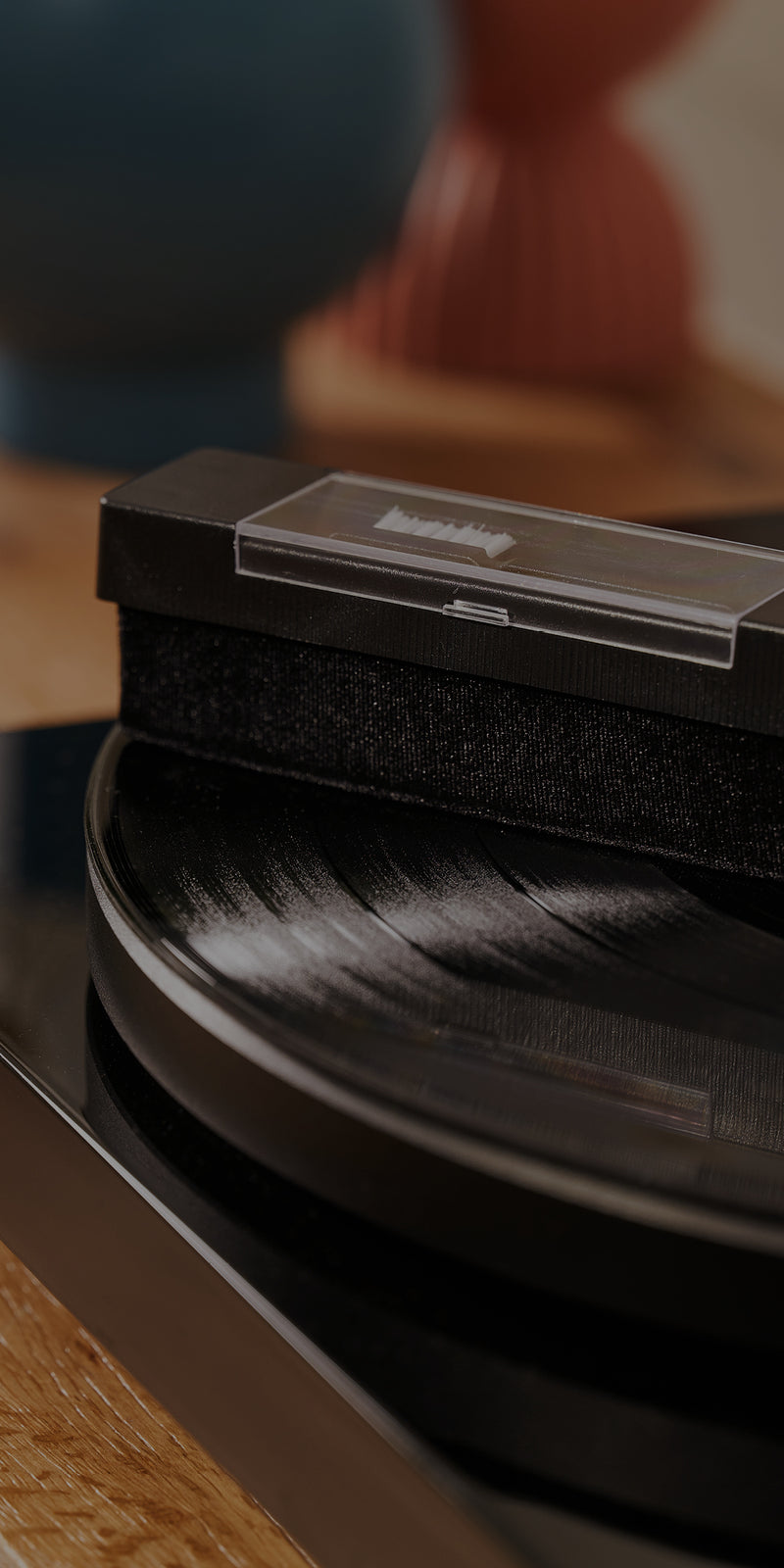 A record cleaning brush cleans a vinyl record on a turntable.